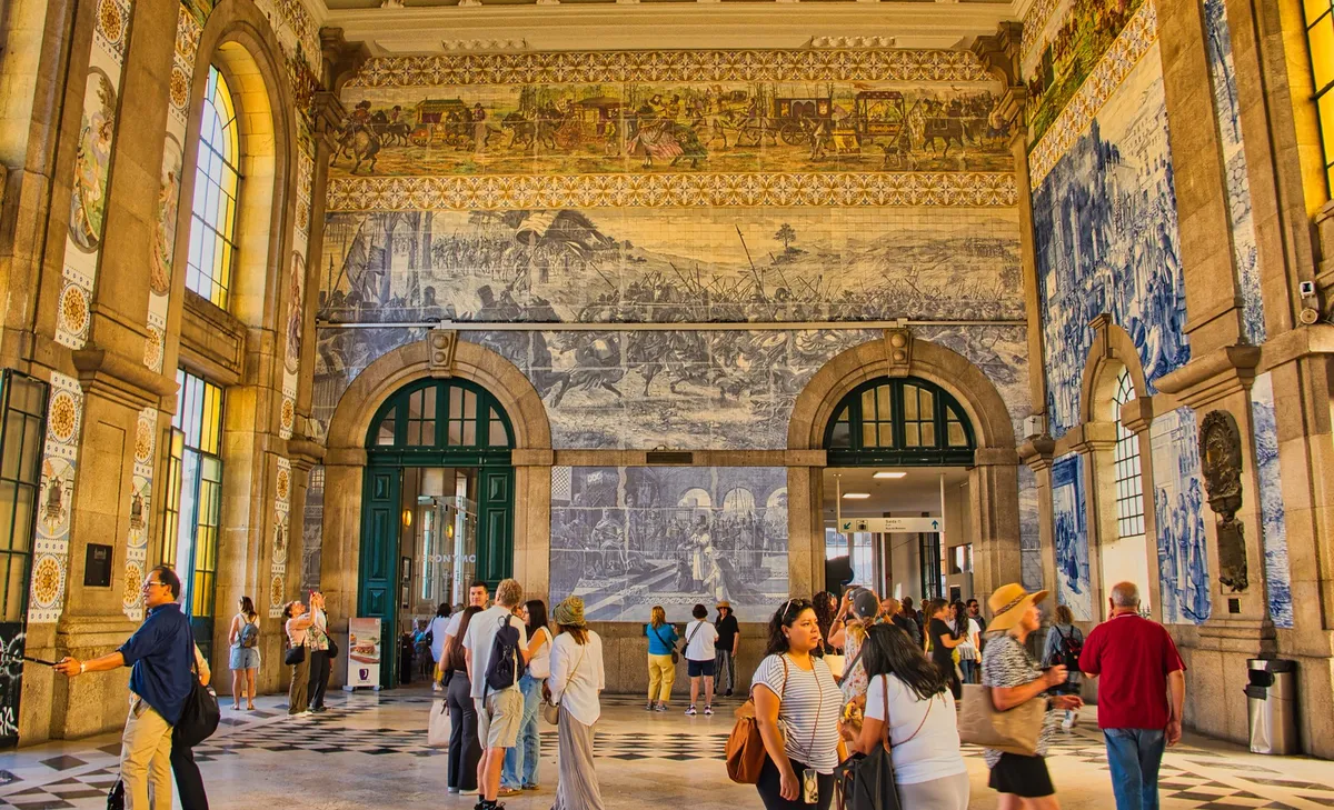 Massive blue and white azulejo tile murals lining the walls inside São Bento Station