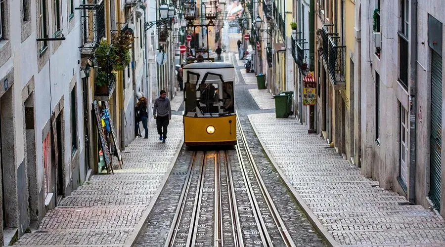 A steep, narrow cobblestone street in Lisbon being serviced via the funicular da bica