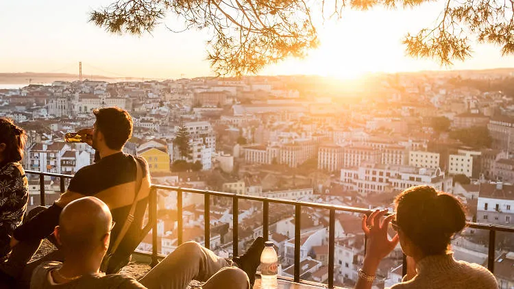 People watching the sunset over Lisbon from a miradouro
