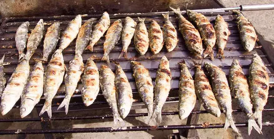 Fresh fish grilling over charcoal on the street outside a seafood restaurant in Matosinhos